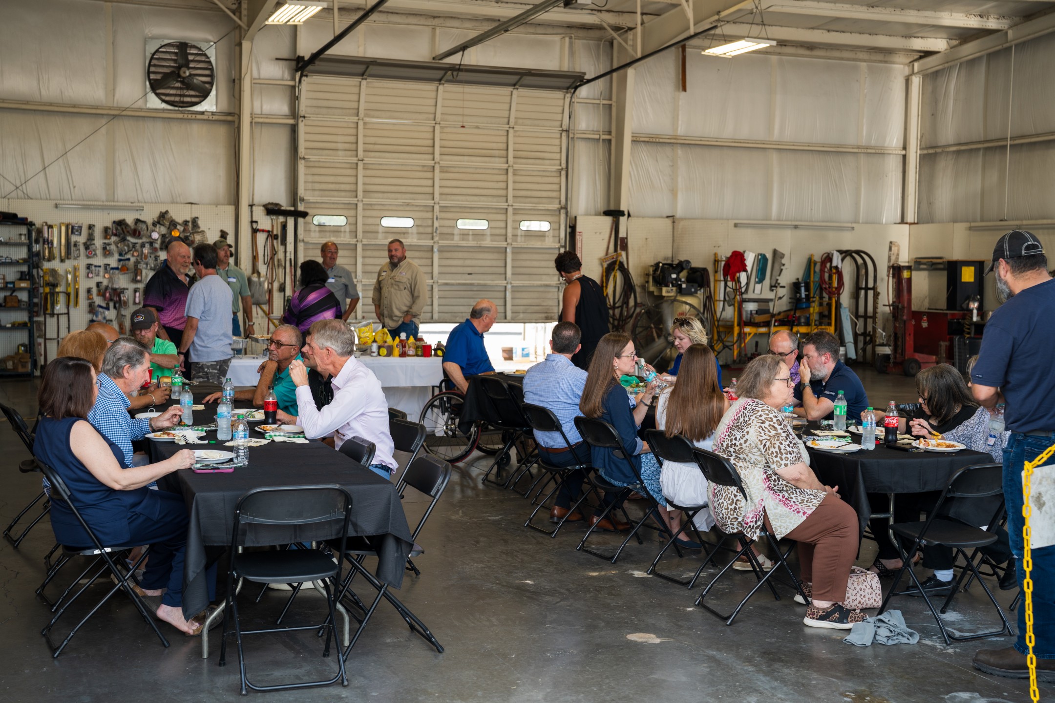 picnic gathering of people inside truck repair shop