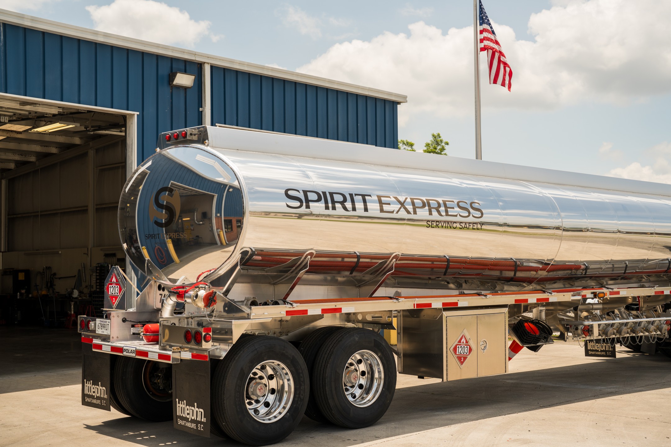 Spirit Express tanker truck in front of building and American Flag